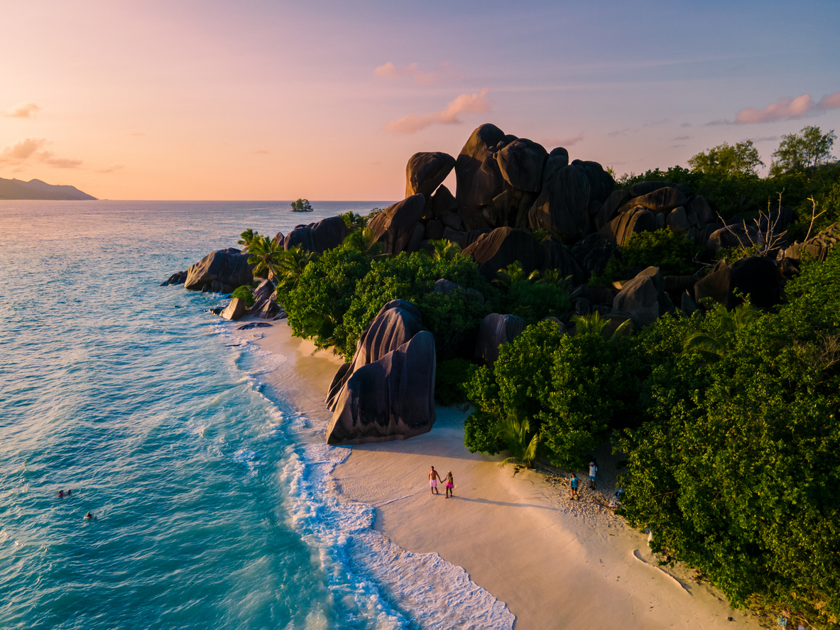 Young couple men and woman on a tropical beach during a luxury vacation in the Seychelles.